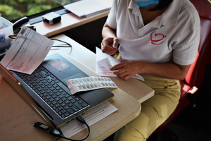zdjęcie przedstawia kobietę wypełniającą dokumentację na komputerze.