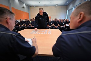 Zdjęcie. Grupa umundurowanych policjantów na sali