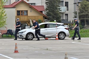 Zdjęcie. Policjanci i samochód na placu podczas konkurencji jazdy samochodem