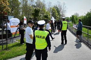 zdjęcie przedstawia policjantów, którzy podchodzą do grupy kolarzy