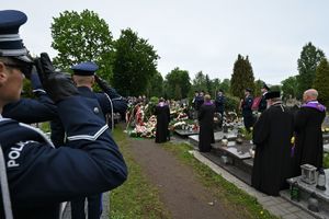 Uczestnicy ceremonii pogrzebowej na cmentarzu