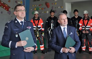Na zdjęciu komendant wojewódzki oraz prezes stoją obok siebie, trzymają w rękach podpisane porozumienia.
