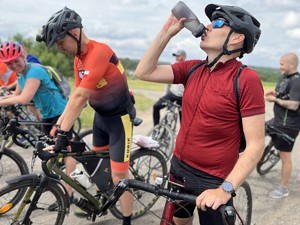 mężczyzna przy rowerze pije wodę z bidonu