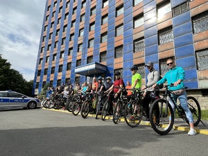 kobiety i mężczyźni z rowerami na zdjęciu pozują przed komendą do zdjęcia