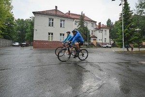 Zdjęcie. Widoczne osoby jadące na rowerach w terenie