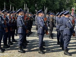 Zdjęcie przedstawia umundurowanych policjantów stojących w szeregu.