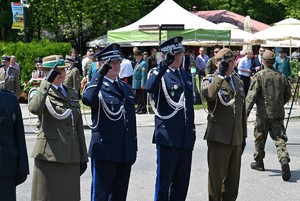 Zdjęcie. Widoczni umundurowani policjanci oraz inne służby mundurowe i uczestnicy uroczystości na Skwerze 100-lecia powstań śląskich w parku śląskim