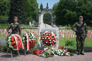 Zdjęcie przedstawia żołnierzy na tle wieńców oraz flag na uroczystości.