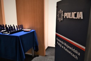 Na zdjęciu na pierwszym planie logo policji i napis Komenda Wojewódzka Policji, w tle odznaczenia leżące na stole.