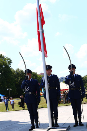 Na zdjęciu policjanci podczas wciągania flagi Polski na maszt.