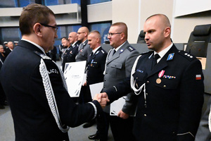 Komendant Wojewódzki Policji w Katowicach wręcza decyzję o awansie policjantowi.