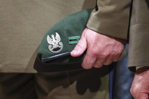 zielony beret w ręce żołnierza