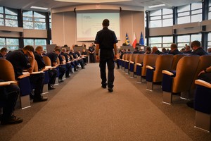 Zdjęcie. Aula, na której siedzą umundurowani policjanci biorący udział w teście wiedzy