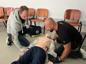 Na zdjęciu uczestnicy szkolenia, którzy udzielają kwalifikowanej pierwszej pomocy osobie dorosłej (fantom).