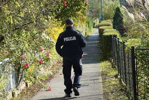 policjant spaceruje po ogrodach działkowych
