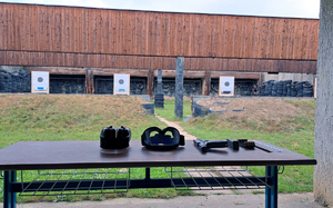 Zdjęcie przedstawiające broń oraz sprzęt przygotowany na strzelnicy.
