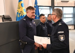 zdjęcie przedstawia policjanta, który odbiera gratulacje od Komendanta