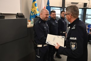 zdjęcie przedstawia policjanta, który odbiera gratulacje od Komendanta