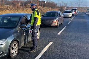 na zdjęciu policjant ruchu drogowego sprawdza trzeźwość kierujących