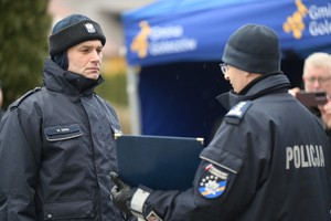 Zdjęcie. Komendant wręcza tabliczkę pamiątkowa policjantowi