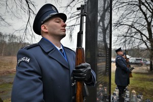 Na zdjęciu policjant z warty honorowej przy pomniku.
