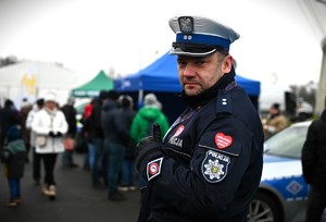 Zdjęcie. Policjant z serduszkiem Wielkiej Orkiestry na ramieniu.