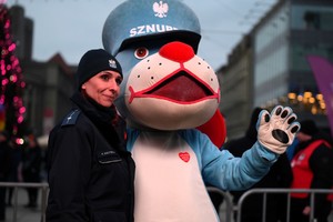 Policjantka z maskotką Sznupka podczas aukcji charytatywnej z okazji WOŚP.