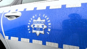Zdjęcie przedstawia oznakowany radiowóz oraz napis na radiowozie &quot;Pomagamy i chronimy&quot;.