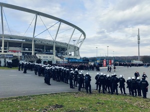 Umundurowani policjanci i kibice na tle Stadionu Śląskiego
