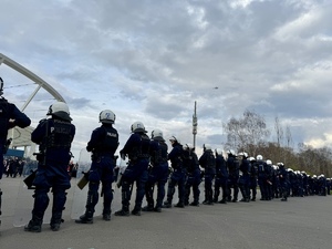 Umundurowani policjanci na tle Stadionu Śląskiego i widoczny lecący śmigłowiec