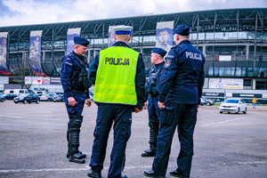 Umundurowani policjanci rozmawiający na tle Stadionu Śląskiego