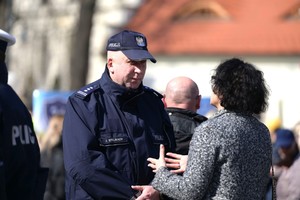 Zastępca Komendanta Wojewódzkiego Policji w Katowicach rozmawia z kobietą