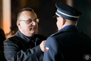 Grzegorz Grześkowiak wręcza odznaczenie okolicznościowe policjantowi