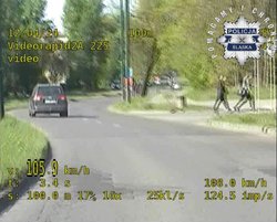 Zdjęcie z nagrania z wideorejestratora z logo śląskiej policji, na którym na jezdni widać samochód.