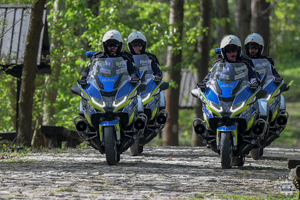 Na zdjęciu czterej policyjni motocykliści jadący drogą na motocyklach.