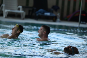 policjanci w basenie doskonalą się w zakresie holowania na brzeg drugiej osoby