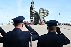 Zdjęcie przedstawia komendantów podczas oddawania honorów, w tle pomnik.