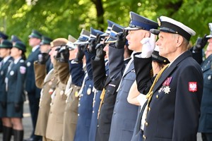 Zdjęcie przedstawia służby mundurowe podczas składania honorów