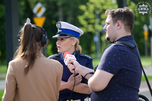 Na zdjęciu policjantka rozmawia z dziennikarzami podczas konferencji prasowej.