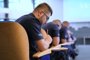 Na zdjęciu policjanci podczas pisemnego testu z wiedzy ogólnej.