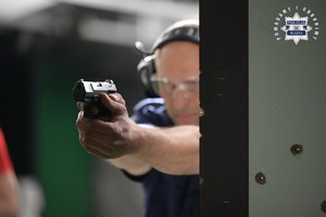 Na zdjęciu widać policjanta na strzelnicy z bronią w ręku.