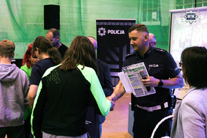 Na zdjęciu umundurowany policjant oraz uczestnicy Turnieju Bezpieczeństwa Ruchu Drogowego.