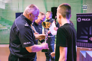 Na zdjęciu umundurowani policjanci, wręczają nagrody uczestnikom Turnieju Bezpieczeństwa Ruchu Drogowego.