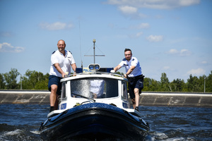 Na zdjęciu widać umundurowanych policjantów na łodzi motorowej, którzy patrolują zbiornik wodny.