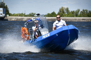 Na zdjęciu widać dwóch umundurowanych policjantów, patrolujących zbiornik wodny, łodzią motorową.