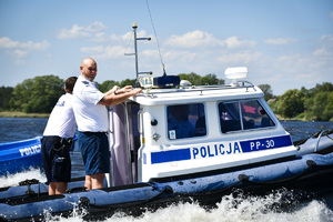 Na zdjęciu widać umundurowanych policjantów, którzy patrolują zbiornik wodny.