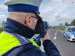 Policjant mierzący prędkość samochodów na drodze