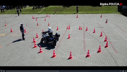 Stopklatka z filmu przedstawiająca policyjnego motocyklistę na torze