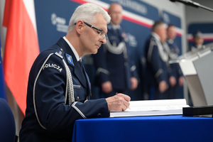 Komendant Wojewódzki Policji w Katowicach podpisuje pamiątkową księgę