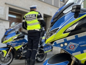 zdjęcie kolorowe przedstawiające umundurowanego policjanta obok motocykli policyjnych